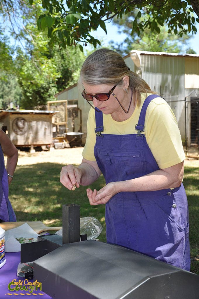 Jan adding wood pellets to the outdoor pizza oven