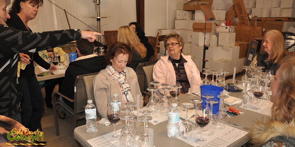 Corinne and Kat pouring wine for wine blending class participants