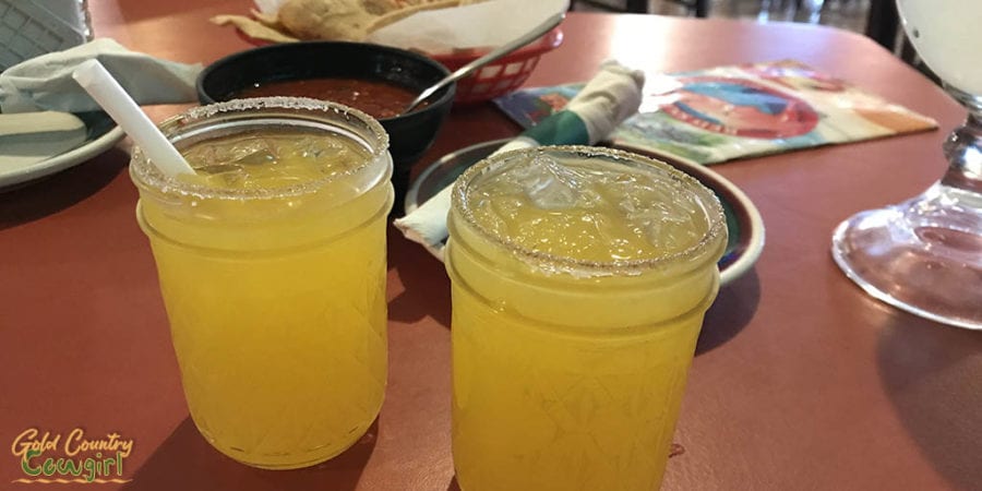 two small jars containing mango margaritas