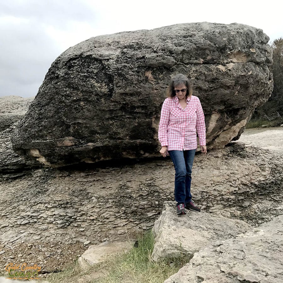 female walking in front of large boulder to show perspective