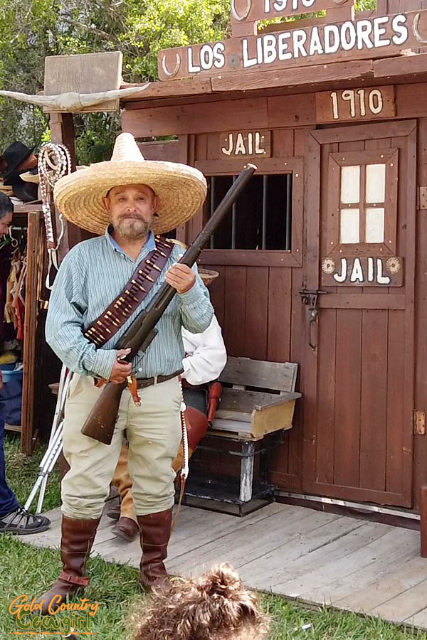 man in costume with rifle and large straw hat
