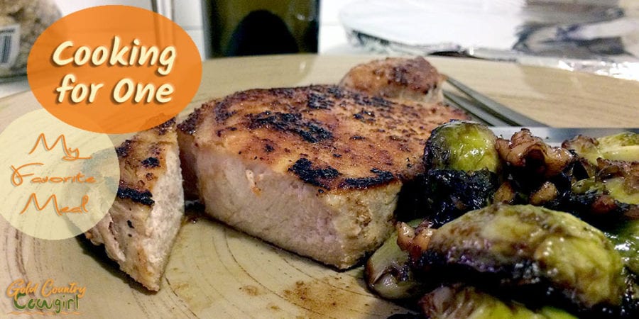 pork chop and brussels sprout dinner with text overlay: Cooking for One My Favorite Meal