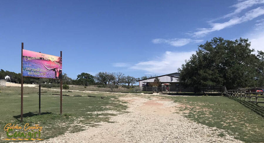 sign and distant view of Chisholm Trail Winery in Fredericksburg