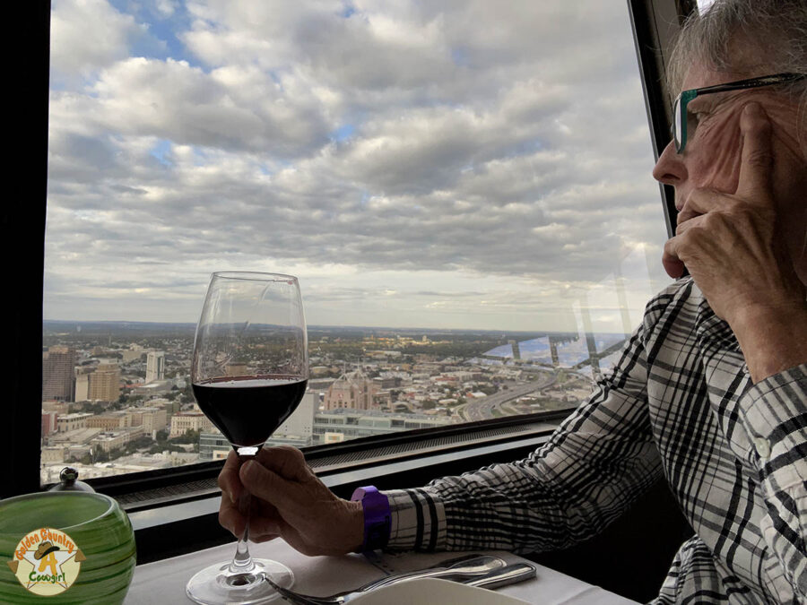 woman looking at the view holding a glass of wine at Tower of the Americas