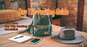 Back pack on a bed ready to be packed with some items suggested in the day trip packing guide: notepad and pen, cell phone and wide-brimmed hat.