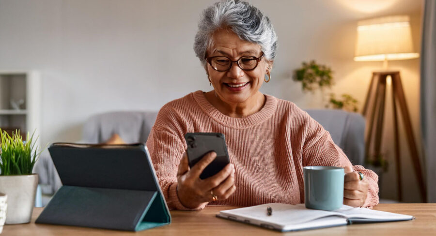 an adult senior woman looking at her phone in a home setting